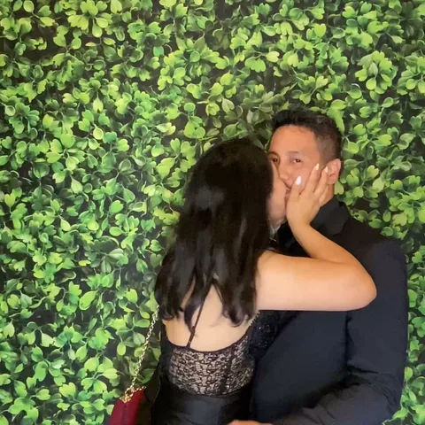 Couple sharing a kiss in a photo booth Boomerang