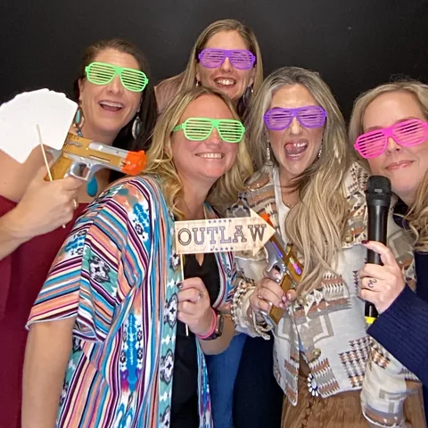 Friends in shutter shades posing at the photo booth at Caddo Creek