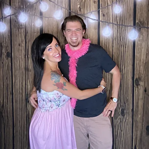 Two guests posing with a pink feather boa at Tynli Timber Events