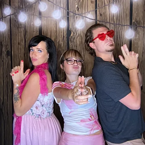 Three friends posing with party props at Tynli Timber Events